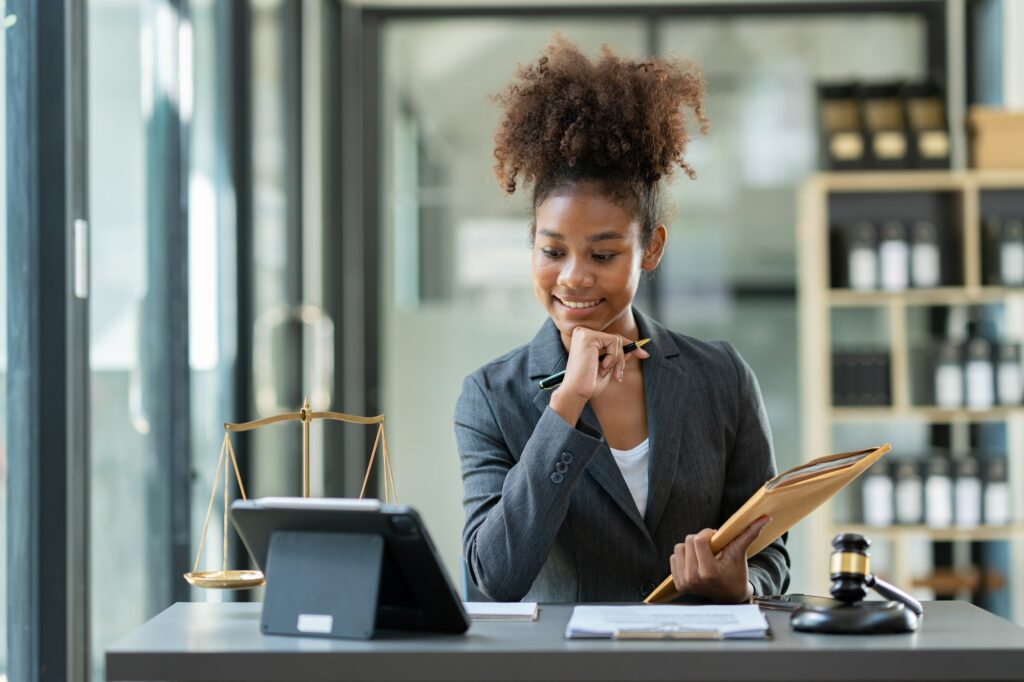 Successful african american woman lawyer or legal advisor working at a desk and holding an envelope