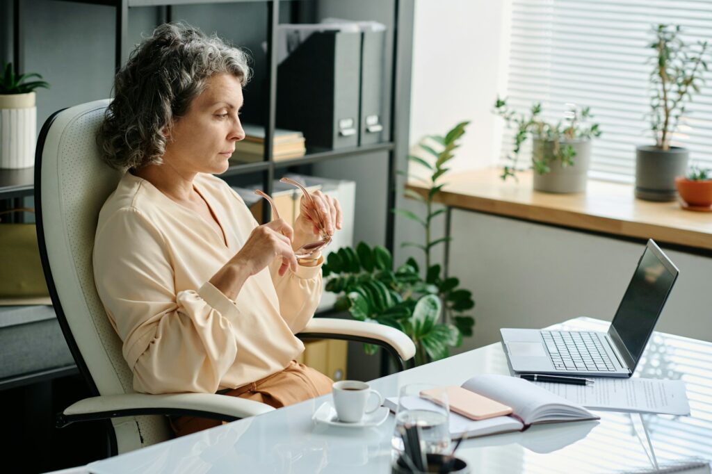 Serious female chief executive officer looking at laptop screen in office